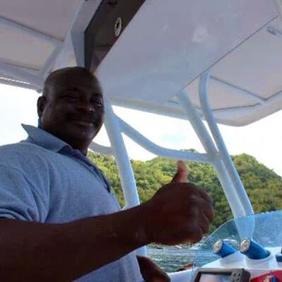 Captain Spencer gives a thumbs up at the helm of his speedboat, Spencer Ambrose Tours, St. Lucia