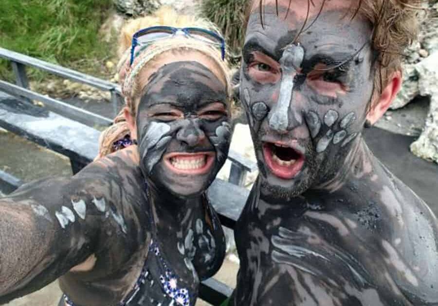 A couple painted in mud enjoy the Mud Baths on a Spencer Ambrose Tour, St. Lucia